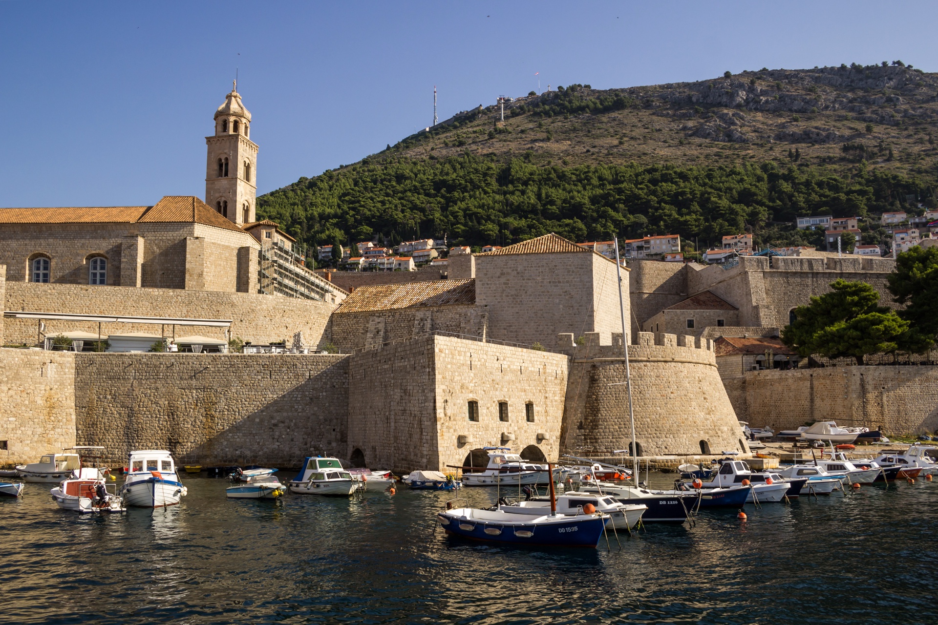 Private charter yacht off the Dubrovnik city walls at golden hour