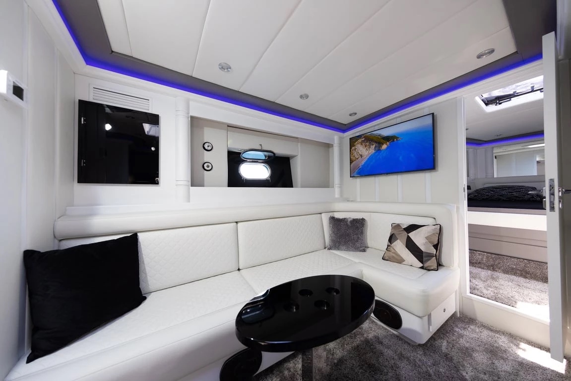 Saloon seating on Bond 007 with a white corner sofa, black cocktail table and wall-mounted TV