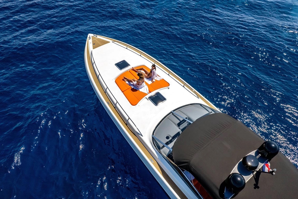 Aerial view of Bond 007's bow with guests relaxing on the orange sun pads over deep blue water