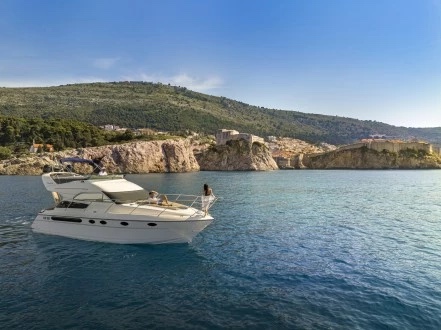 Fairline Phantom 40 lying at rest beneath wooded cliffs, the old town fortifications in the distance
