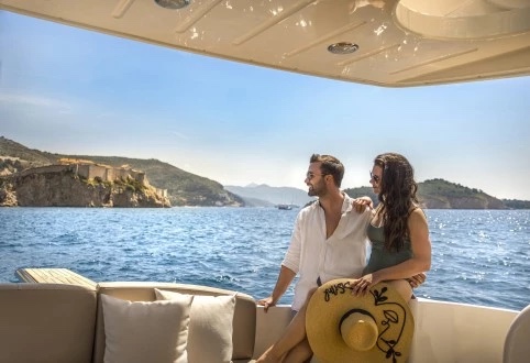 Guests seated in the shaded stern of the Fairline Phantom 40 watching a clifftop fortress slide past