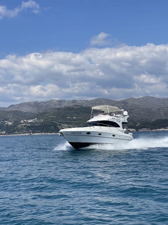 Galeon 330 Fly at speed on the Adriatic, bow spray flying with the coastal hills behind