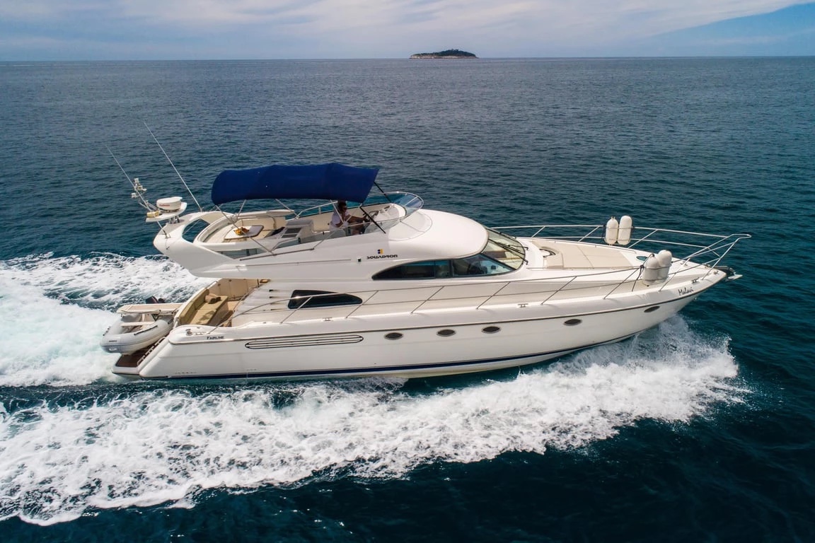 Side profile of the Malavi 55 at speed on open water, tender stowed on the stern platform