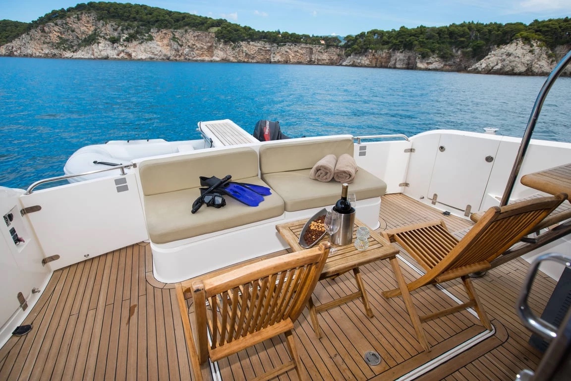Malavi 55 cockpit with teak deck, cushioned bench, snorkelling gear and a table set with wine